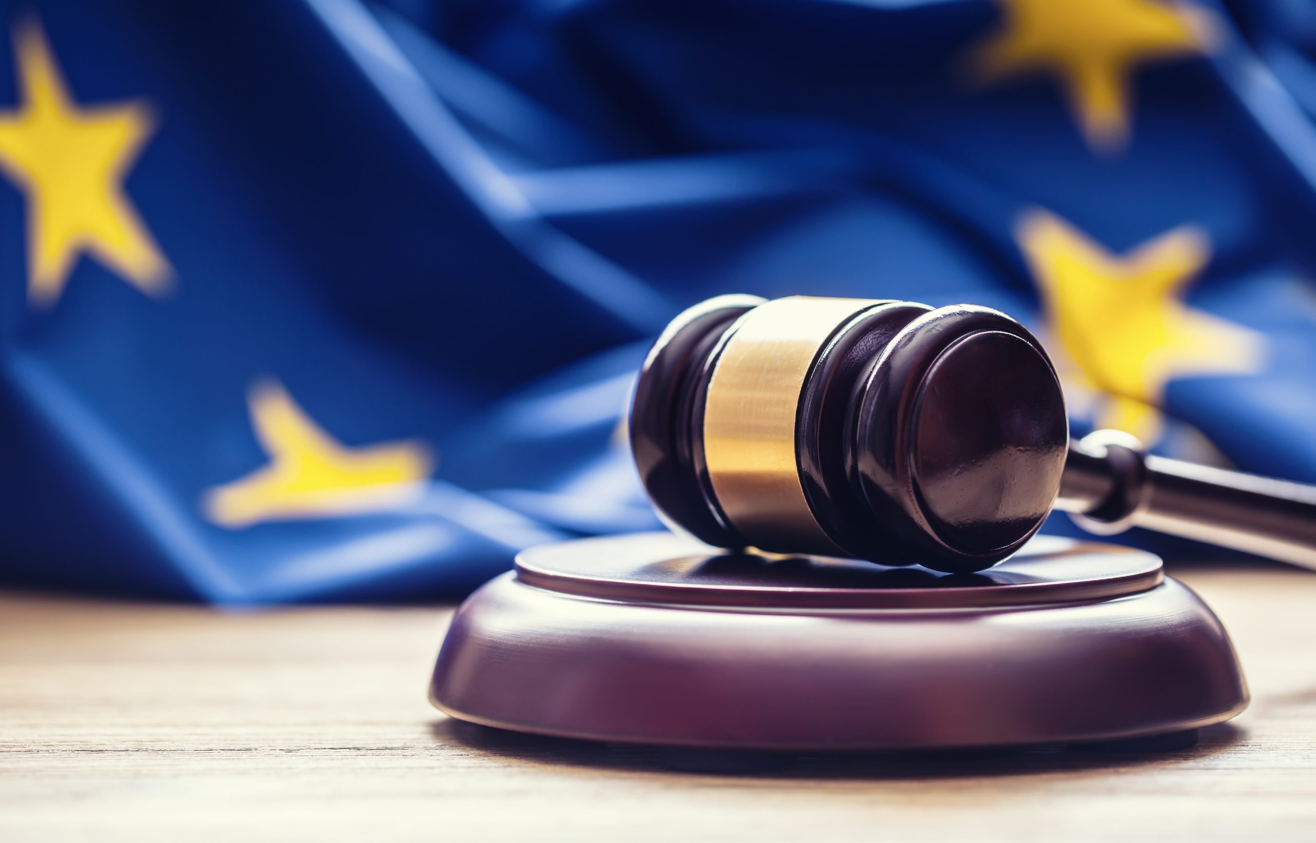 Judges wooden gavel with EU flag in the background.
